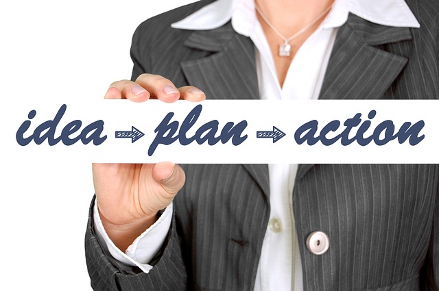 Image of a business woman's torso holding a sign that reads: idea, plan, action